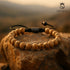 Armband aus Landschaftsjaspis auf Felsen im Sonnenuntergang – UNIQAL Natursteinarmband